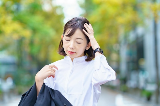 A woman suffering from a headache on street