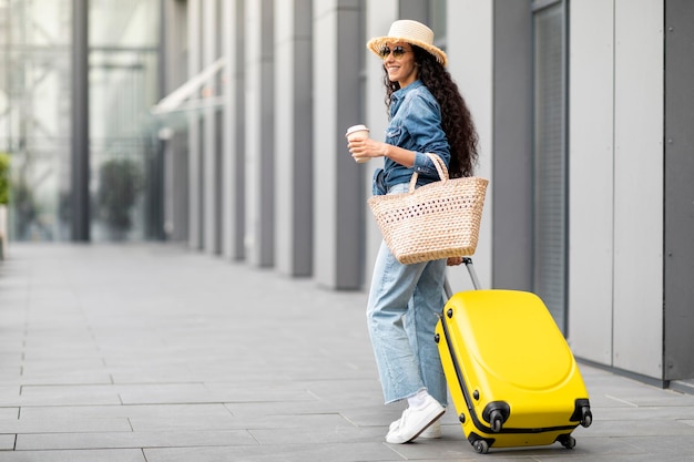 Woman in summer hat and sunglasses going vacation back view