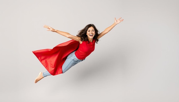 Woman superhero wearing a red cloak on a gray background