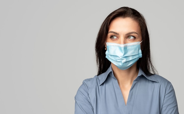 Woman in surgical mask looking away