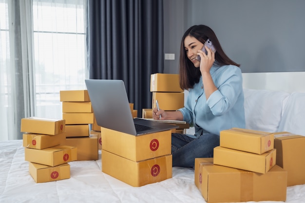 Woman surrounded by boxes using a laptop