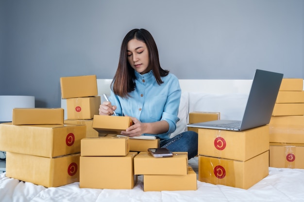 Woman surrounded by boxes using a laptop