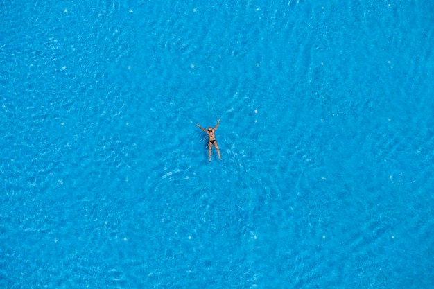 Woman swimming in a pool top view Summer travel and vacation concept