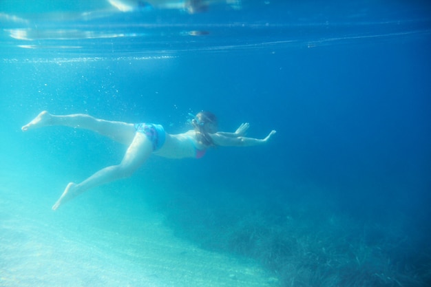 Woman swimming underwater in mediterranean adriatic sea in Croatia