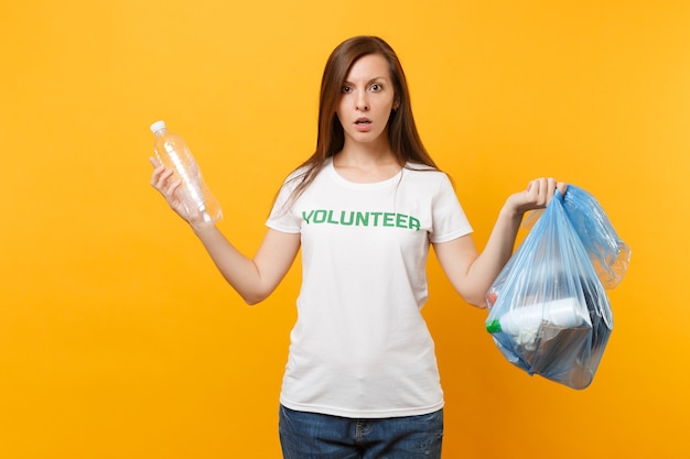 Woman in t-shirt volunteer, trash bag isolated on yellow background. Voluntary free assistance help, charity grace. Environmental pollution problem. Stop nature garbage environment protection concept.