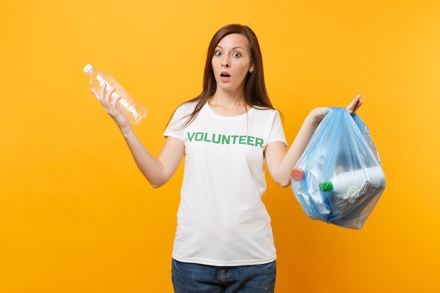 Woman in t-shirt volunteer, trash bag isolated on yellow background. Voluntary free assistance help, charity grace. Environmental pollution problem. Stop nature garbage environment protection concept.