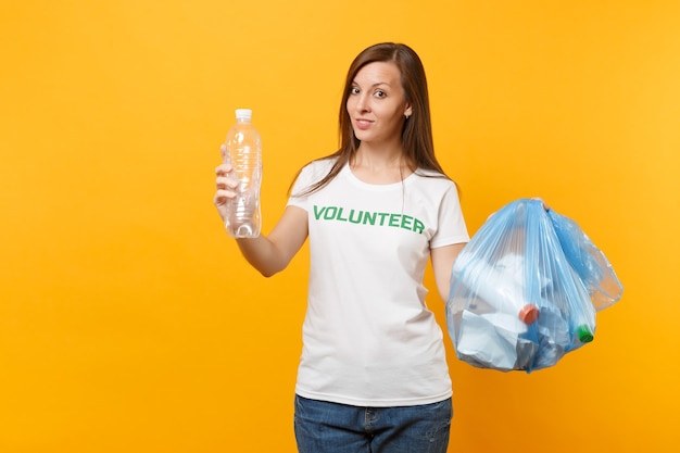 Woman in t-shirt volunteer, trash bag isolated on yellow background. Voluntary free assistance help, charity grace. Environmental pollution problem. Stop nature garbage environment protection concept.