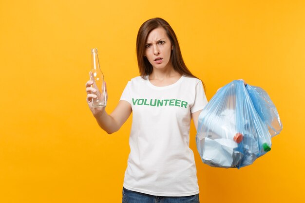 Woman in t-shirt volunteer, trash bag isolated on yellow background. Voluntary free assistance help, charity grace. Environmental pollution problem. Stop nature garbage environment protection concept.