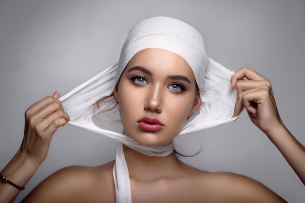 Woman takes off the bandages from her head