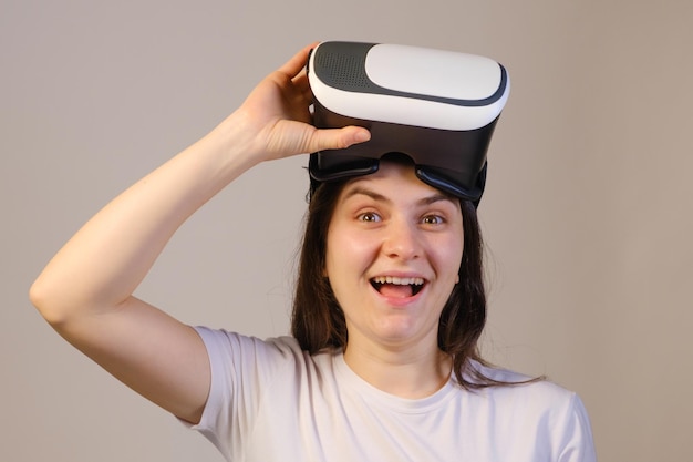 A woman takes off virtual reality glasses and laughs