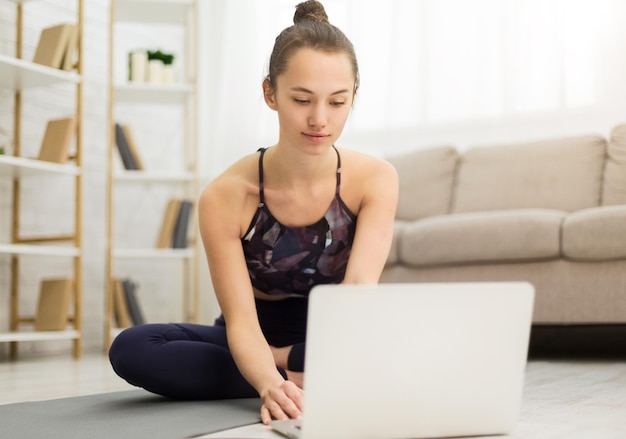 Woman taking break from exercises watching online lesson