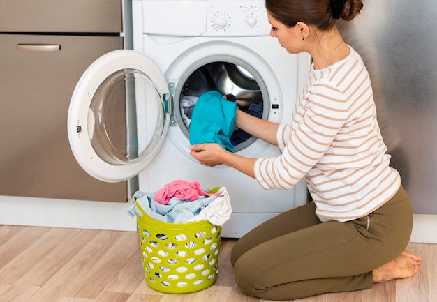 Woman taking clothes out washing machine