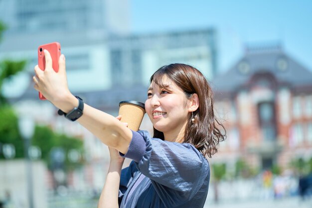 A woman taking a commemorative photo with a smartphone on fine day