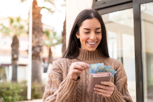 Woman taking a lot of money at outdoors