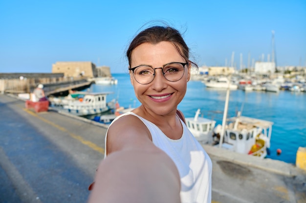 Woman taking photo against the backdrop of historic fortress sea bay