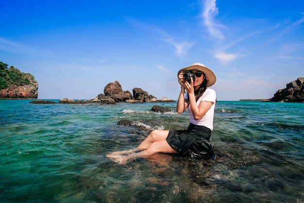 Woman taking photo the sea and relaxing on her vacation.