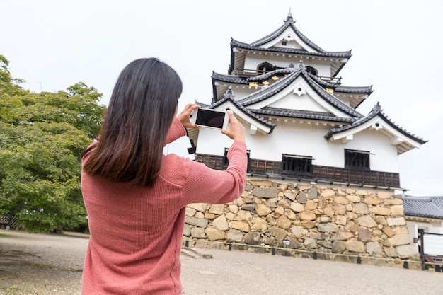 Woman taking photo with mobile phone on Hikone castle