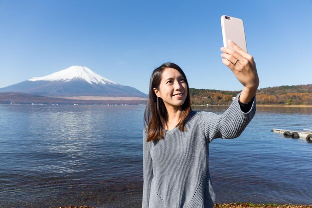 Woman taking photo with Mount Fuji