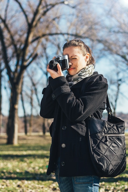 Woman taking a photo with old analog camera