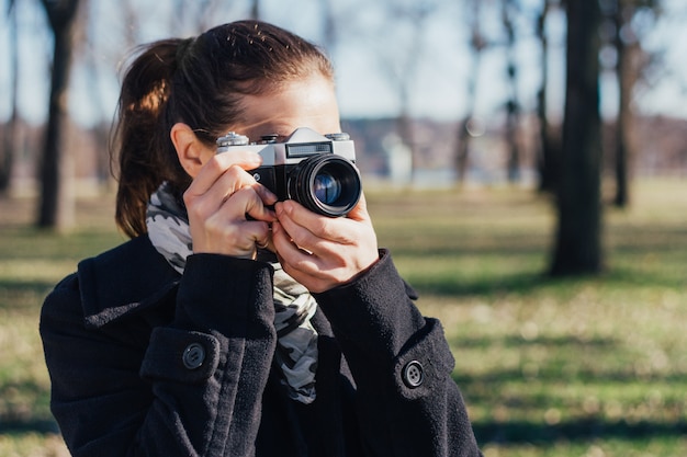 Woman taking a photo with old analog camera