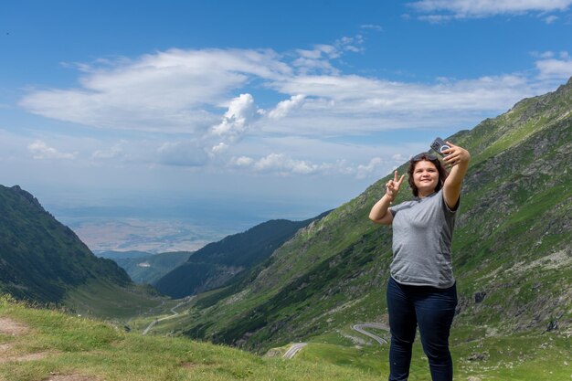 a woman taking a picture of herself in the mountains