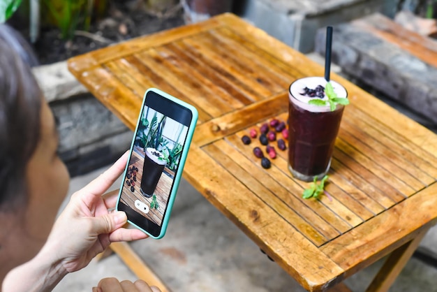 A woman taking picture of mulberry tea for advertisement and social media