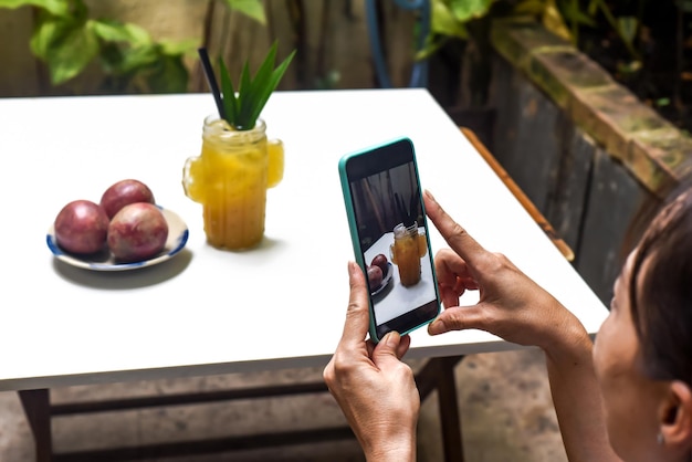 A woman taking picture of passion tea for advertisement and social media