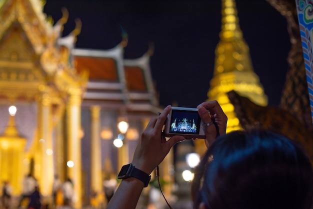 Woman taking picture of Thailand at night and dark sky.