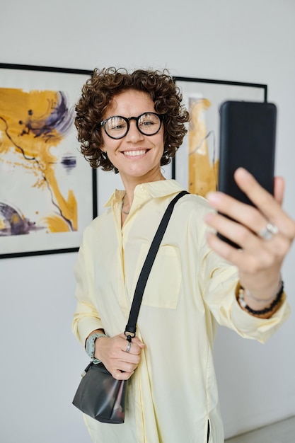 Woman taking selfie at art gallery