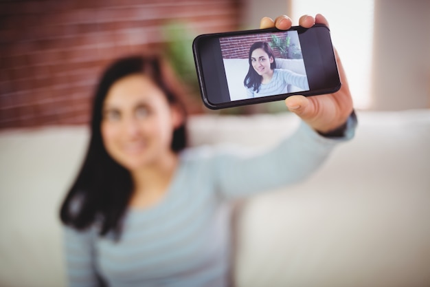 Woman taking selfie at home