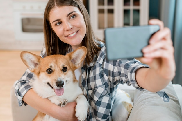 Photo woman taking selfie with her dog