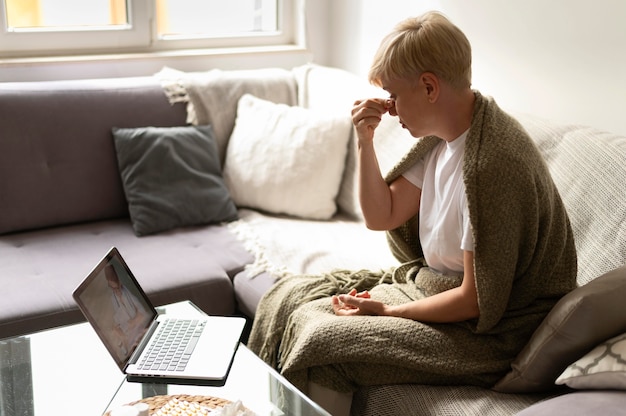 Woman talking to doctor online medium shot