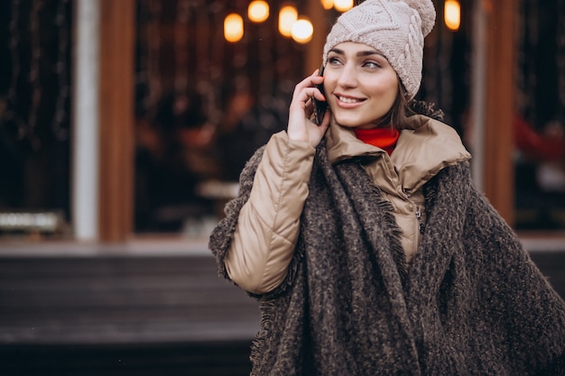 Woman talking on the phone outside bar in winter