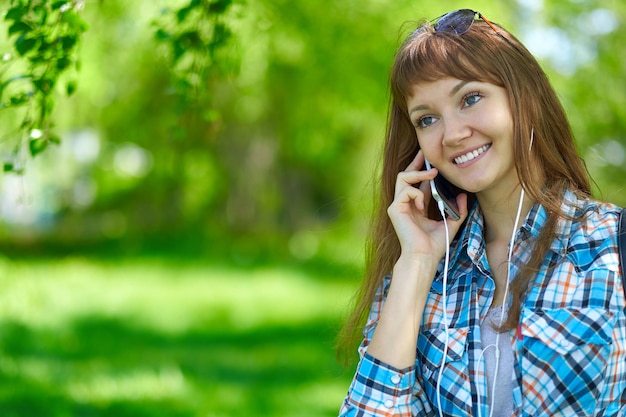 Woman talking on phone in summer park