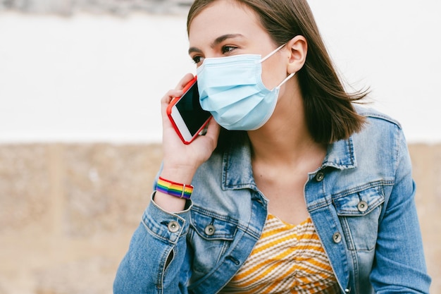 Woman talking on the phone with surgical mask