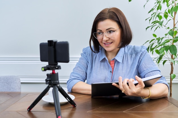 Woman teacher mentor psychologist looking at webcam of smartphone talking counseling