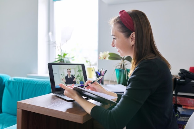 Woman teacher teaching student teenager online using video call on laptop