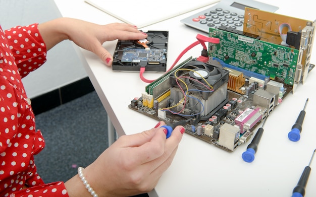 Woman technician repairs a computer