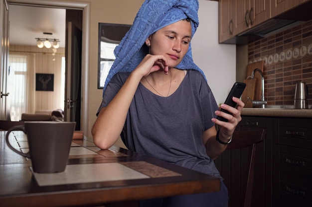 Woman text messaging on mobile phone at home