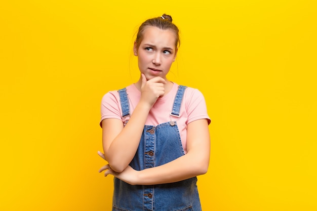 woman thinking, feeling doubtful and confused, with different options, wondering which decision to make