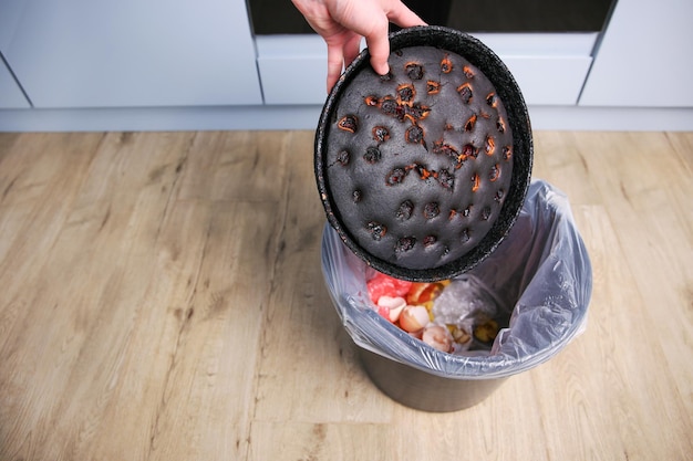 A woman throws a burnt pie in the trash