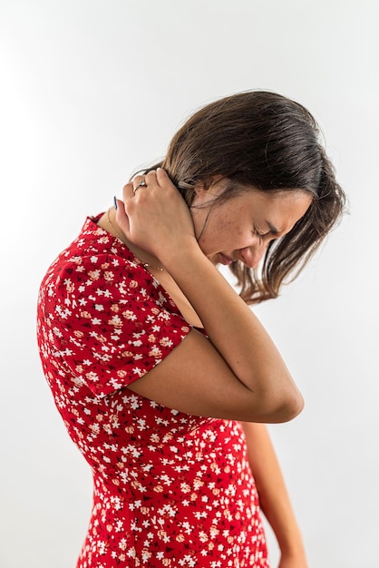 Woman touches her neck with an expression of suffering on her face and closed eyes