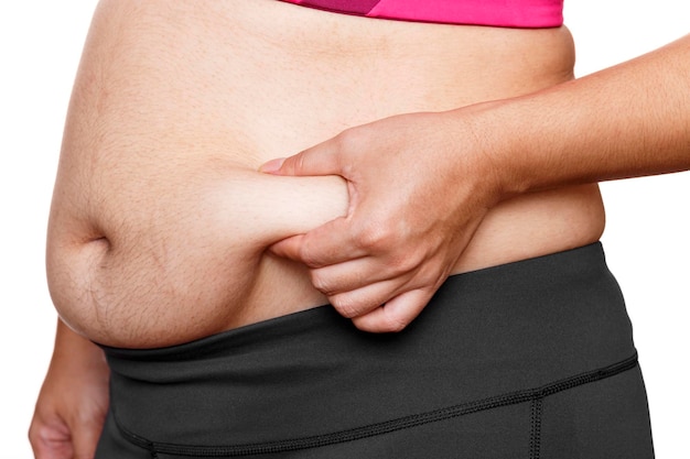 Woman touching his fat belly on white background Woman hand holding excessive belly fat