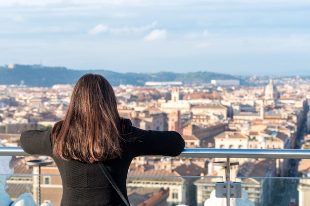 Woman tourist is looking on city Rome from a high point