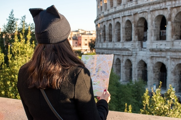 Woman tourist is looking at the map on the street of city