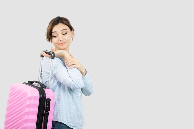 Woman tourist standing and holding pink travel suitcase . High quality photo