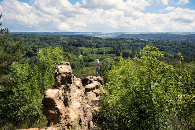 Woman tourist stands on rock top in resort park Kislovodsk Russia