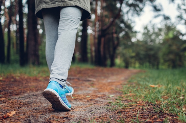 Photo woman tourist walking in spring forest close up of shoes traveling and tourism