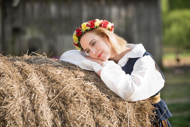 Woman in traditional clothing posing on nature in village