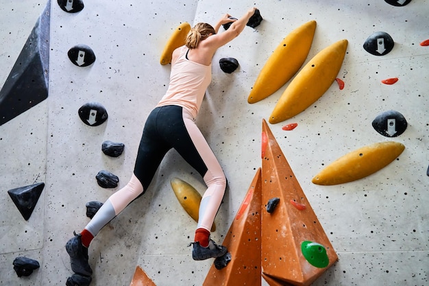 Woman training at bouldering gym Active recreation sports exercises